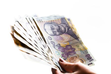 Woman hand giving money like bribe or tips isolated on white background. LEI currency banknotes close up. Reward for hard work, finance and business conceptの写真素材