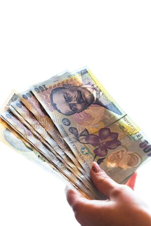 Woman hand giving money like bribe or tips isolated on white background. LEI currency banknotes close up. Reward for hard work, finance and business conceptの写真素材
