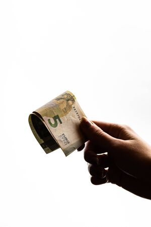 Woman hand giving money like bribe or tips isolated on white background. EURO currency banknotes close up. Reward for hard work, finance and business conceptの写真素材