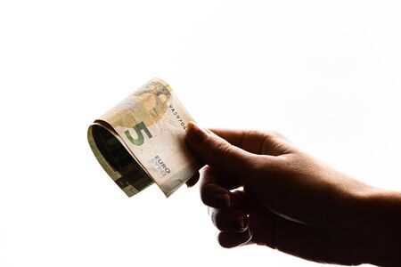 Woman hand giving money like bribe or tips isolated on white background. EURO currency banknotes close up. Reward for hard work, finance and business conceptの写真素材