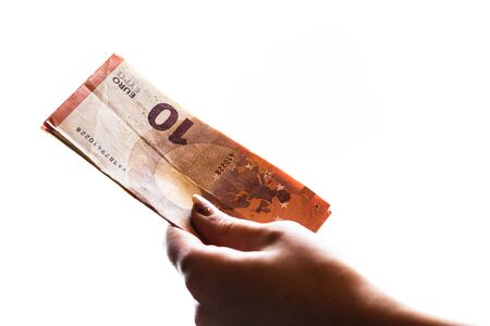 Woman hand giving money like bribe or tips isolated on white background. EURO currency banknotes close up. Reward for hard work, finance and business conceptの写真素材