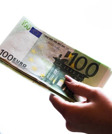 Woman hand giving money like bribe or tips isolated on white background. EURO currency banknotes close up. Reward for hard work, finance and business conceptの写真素材