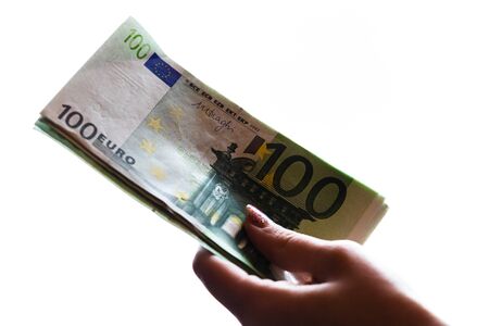 Woman hand giving money like bribe or tips isolated on white background. EURO currency banknotes close up. Reward for hard work, finance and business conceptの写真素材