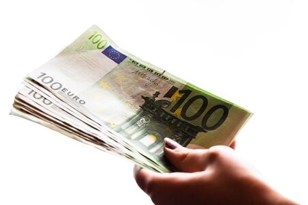 Woman hand giving money like bribe or tips isolated on white background. EURO currency banknotes close up. Reward for hard work, finance and business conceptの写真素材
