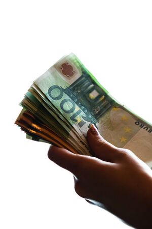 Woman hand giving money like bribe or tips isolated on white background. EURO currency banknotes close up. Reward for hard work, finance and business conceptの写真素材