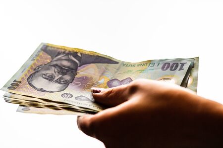 Woman hand giving money like bribe or tips isolated on white background. LEI currency banknotes close up. Reward for hard work, finance and business conceptの写真素材