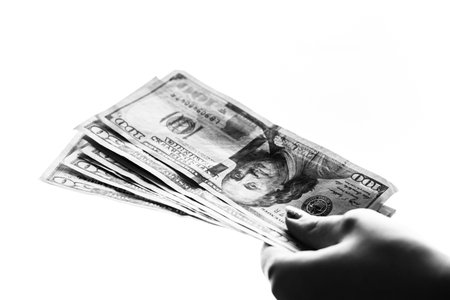 Woman hand giving money like bribe or tips isolated on white background. USD currency banknotes...