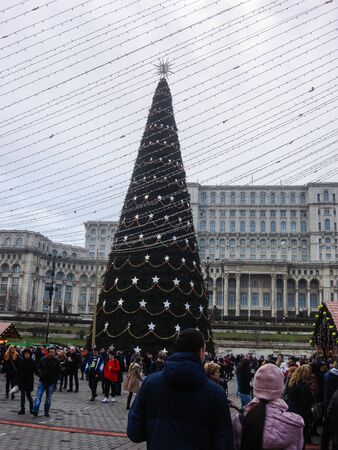 Decorated huge Christmas tree, lights, decorations, hot wine, hot chocolate, presents and people wandering at the Christmas market in Bucharest, Romania, 2019のeditorial素材