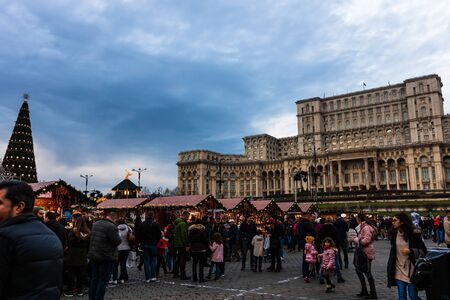 Bucharest Christmas market in front of the Palace of Parliament, Christmas tree, lights, people wandering at the Christmas market in Bucharest, Romania, 2019のeditorial素材