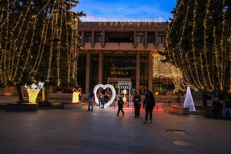Christmas tree and lights in winter holiday market of Targoviste. People celebrating Christmas outdoor in the town square of Targoviste, Romania, 2019のeditorial素材