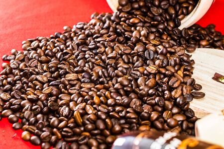 Cup of coffee, wooden coffee jar and roasted coffee beans in a sack on red background, top view, copy space for text, coffee conceptの写真素材