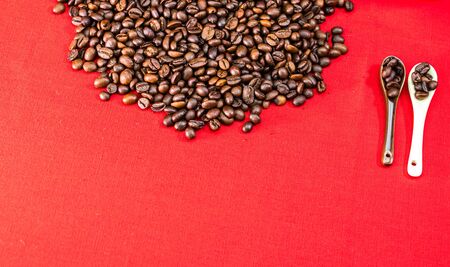 Roasted coffee beans on red background, top view, copy space for text, coffee conceptの写真素材