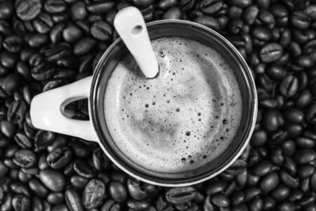 Coffee cup with roasted coffee beans on red background, coffee concept, close up coffee photoの写真素材