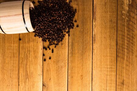Coffee wooden barrel, roasted coffee beans on wooden background, coffee wooden jar top view, copy space for text, close up coffee photoの写真素材
