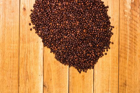 Detail of roasted coffee beans on wooden background, top view, copy space for text, close up coffee photoの写真素材
