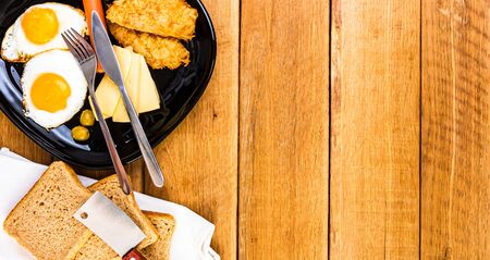 Fried egg, wholegrain toast, cheese, hotdog and cup of coffee for breakfast over wooden table, top view, copy space, breakfast conceptの写真素材