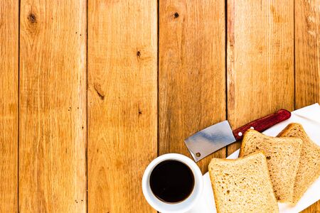 Cup of coffee and wholegrain toast over wooden table, top view, copy space. Breakfast conceptの写真素材