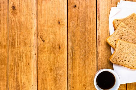 Cup of coffee and wholegrain toast over wooden table, top view, copy space. Breakfast conceptの写真素材