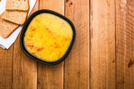 Chicken soup with sour cream, wholegrain toast on white napkin and croutons for lunch over wooden table, top view, copy space, lunch conceptの写真素材