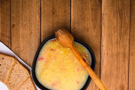 Chicken soup with sour cream, wholegrain toast on white napkin and croutons for lunch over wooden table, top view, copy space, lunch conceptの写真素材