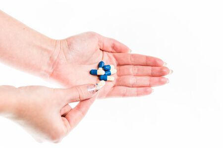 Hand holding antibiotics capsules or painkillers isolated on white. Medicine concept, pills close up, copy spaceの写真素材