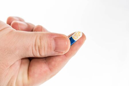 Hand holding antibiotics capsules or painkillers isolated on white. Medicine concept, pills close up, copy spaceの写真素材