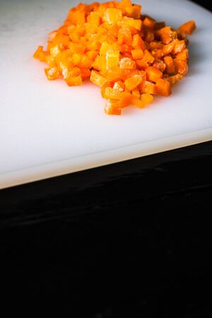 Fresh and frozen chopped vegetables,  Chopped carrots on white cutting board.の写真素材