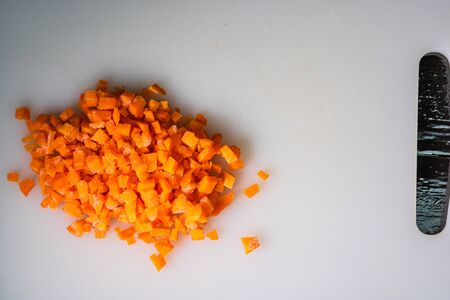 Fresh and frozen chopped vegetables,  Chopped carrots on white cutting board.の写真素材