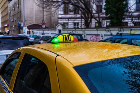 Taxi sign on yellow cab in the morning in Bucharest, Romania, 2020のeditorial素材