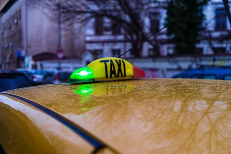 Taxi sign on yellow cab in the morning in Bucharest, Romania, 2020のeditorial素材