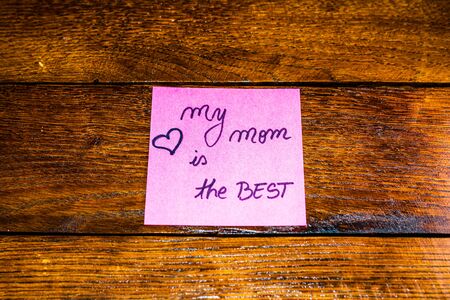 Writing My mom is the best on memo post reminder. Text on sticky paper. Mother`s day concept.の写真素材