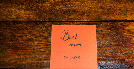 Writing best mom ever on memo post reminder. Text on sticky paper. Mother`s day concept.