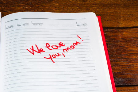 Mother`s day concept. Writing text for mother on personal agenda. We love you, mom.
