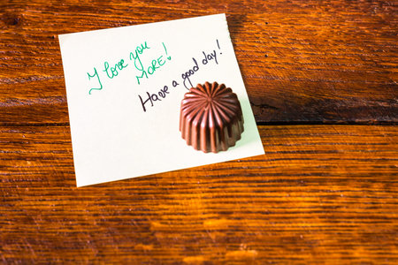 Chocolate bonbon, praline on memo post reminder with love text.