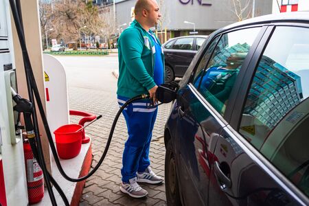 Man at gas station filling up the car with petrol in Bucharest, Romania, 2020のeditorial素材