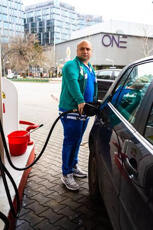 Man at gas station filling up the car with petrol in Bucharest, Romania, 2020のeditorial素材
