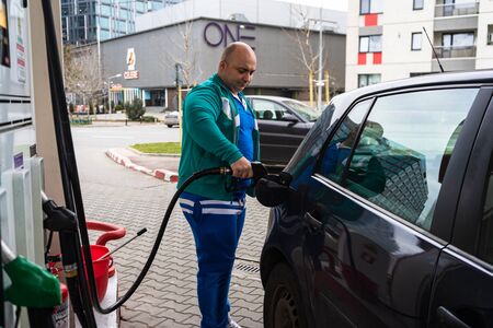 Man at gas station filling up the car with petrol in Bucharest, Romania, 2020のeditorial素材