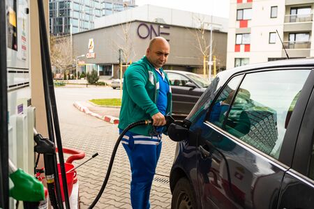Man at gas station filling up the car with petrol in Bucharest, Romania, 2020のeditorial素材