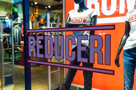 Discount (reduceri), sale signs, red poster offer, mock up advertise display frame over clothes in shopping mall or department store for show promotion product at AFI Cotroceni Mall from Bucharest, Romania, 2020のeditorial素材