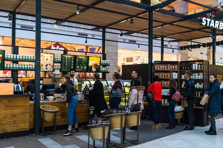 People sitting, waiting in line and working at the Starbucks at AFI Cotroceni Mall from Bucharest, Romania, 2020のeditorial素材