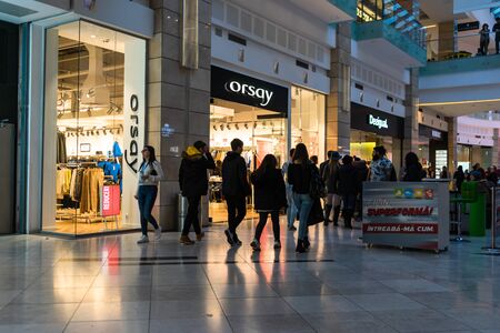 Discount, sale signs, red poster offer, mock up advertise display frame over clothes in shopping mall or department store for show promotion product at AFI Cotroceni Mall from Bucharest, Romania, 2020のeditorial素材