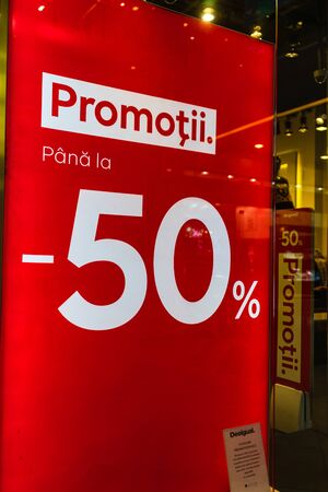 Discount, sale signs, red poster offer, mock up advertise display frame over clothes in shopping mall or department store for show promotion product at AFI Cotroceni Mall from Bucharest, Romania, 2020のeditorial素材