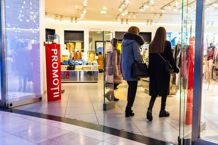 Discount, sale signs, woman entering in shopping mall store at AFI Cotroceni Mall from Bucharest, Romania, 2020のeditorial素材