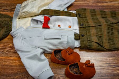 Children, baby suit for baptize party. Stylish baby boy clothing for baptism on light brown background, top viewの写真素材