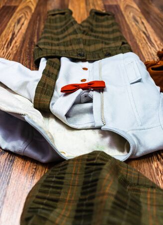 Children, baby suit for baptize party. Stylish baby boy clothing for baptism on light brown background, top viewの写真素材