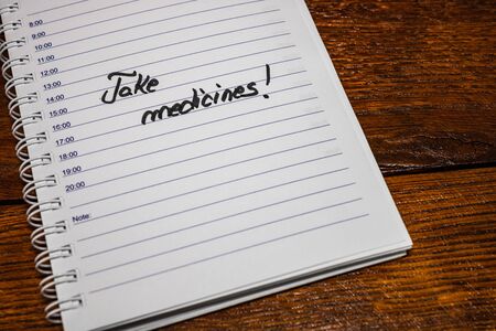 Take medicines, handwriting text on page of office agenda. Copy space.の写真素材