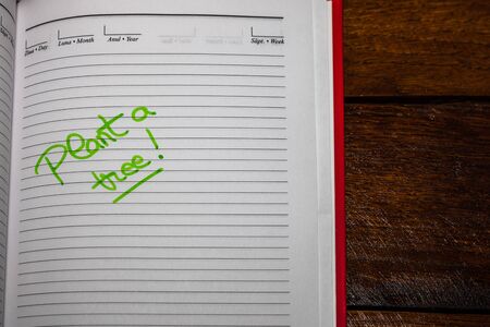Plant a tree, handwriting text on page of office agenda. Copy space.の写真素材