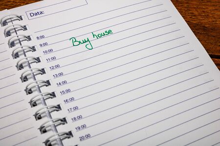 Buy house, handwriting text on page of office agenda. Copy space.の写真素材