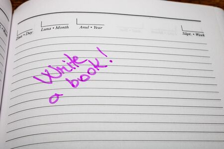 Write a book, handwriting text on page of office agenda. Copy space.の写真素材