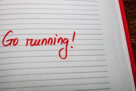 Go running, handwriting text on page of office agenda. Copy space.の写真素材